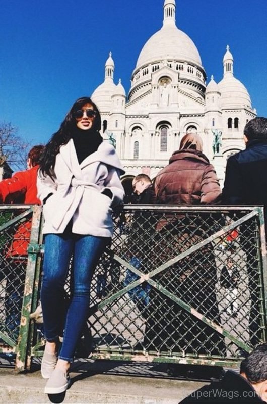 Claudia Sampedro Wearing White Long Coat And Blue Jeans